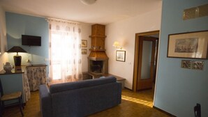 A living room with a sofa, a fireplace, and a television. - Apartment in Villa Valentini, seafront, Gulf of Gaeta, parking included (Marina di Minturno)