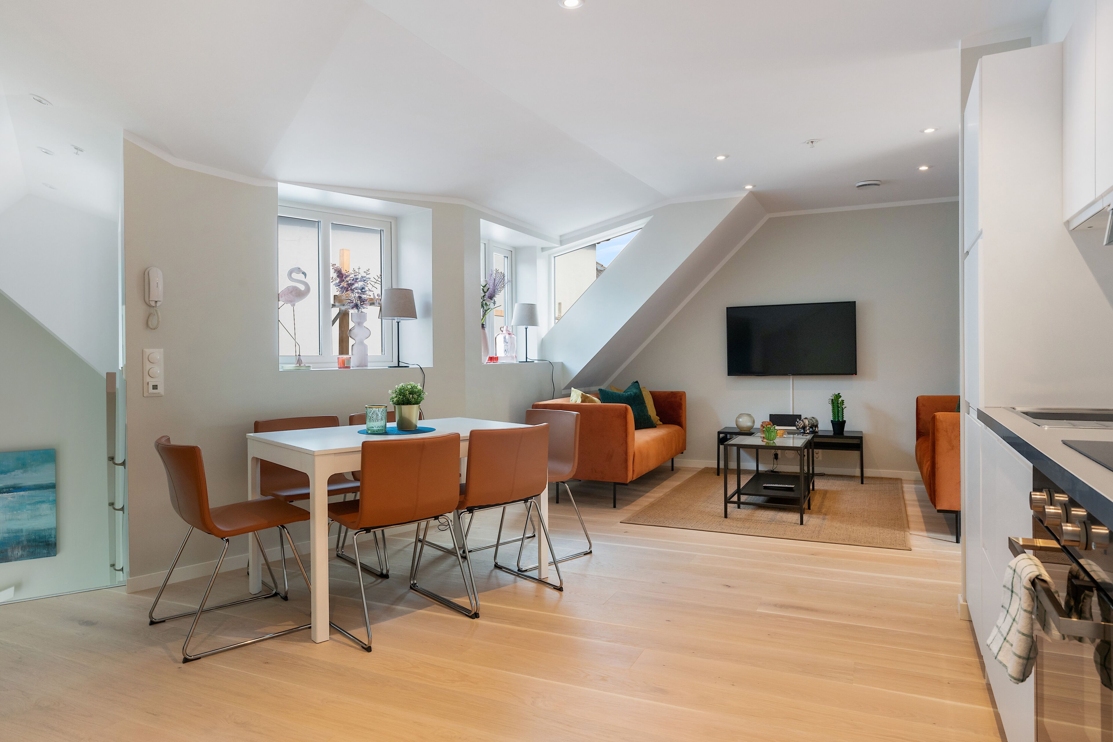 A modern apartment with a dining area, living space, and kitchen.