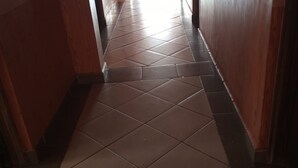 Un couloir doté d’un sol carrelé et de murs en bois.