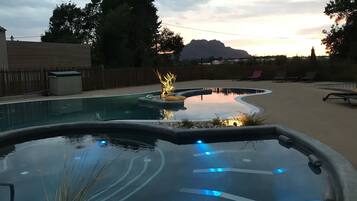 Een buitenzwembad, parasols bij het zwembad en ligstoelen