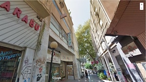 Une rue étroite bordée de boutiques, dont une dont la devanture, bien visible, porte une enseigne indiquant « CARUSEL ».