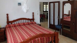 A bedroom with a wooden bed, a mirror, and a door leading to another room. - Villa ‘‘ Sapotille ’’ calm all comfort wonderful setting at Le Moule (Le Moule)
