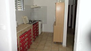 A small kitchen with a stove, sink, and a red patterned cabinet. - Villa ‘‘ Sapotille ’’ calm all comfort wonderful setting at Le Moule (Le Moule)