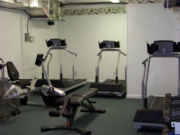 A gym with treadmills, a stationary bike, and a weight bench. - Walk to the Beach at Nettles Island 4 bed/2 bath sleeps 8 (Jensen Beach)