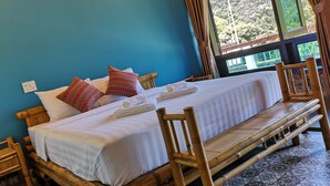 A bed with white bedding, red patterned pillows, and a wooden headboard. - Trang An Ecolodge (Tay Hoa Lu)