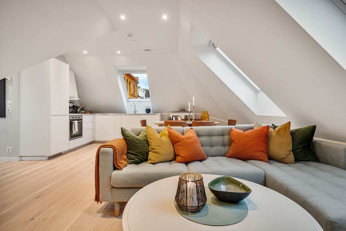 A modern loft apartment with a kitchen, dining area, and living room.