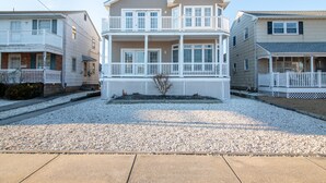 A beachfront residential building with a two-story structure, a balcony, and a covered porch area. - Gem of the Gold Coast. Book now and save for summer 2027!! Weeks will go fast!! (Ocean City)