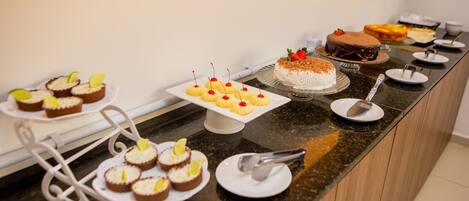 A buffet with various desserts including cakes and cupcakes, arranged on a counter.