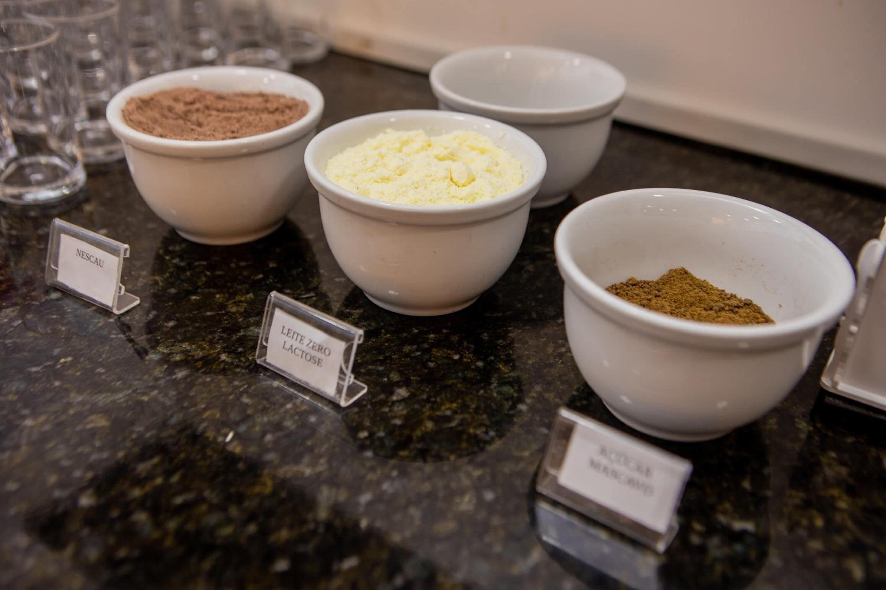 Uma bancada de cozinha com tigelas identificadas contendo diferentes ingredientes.