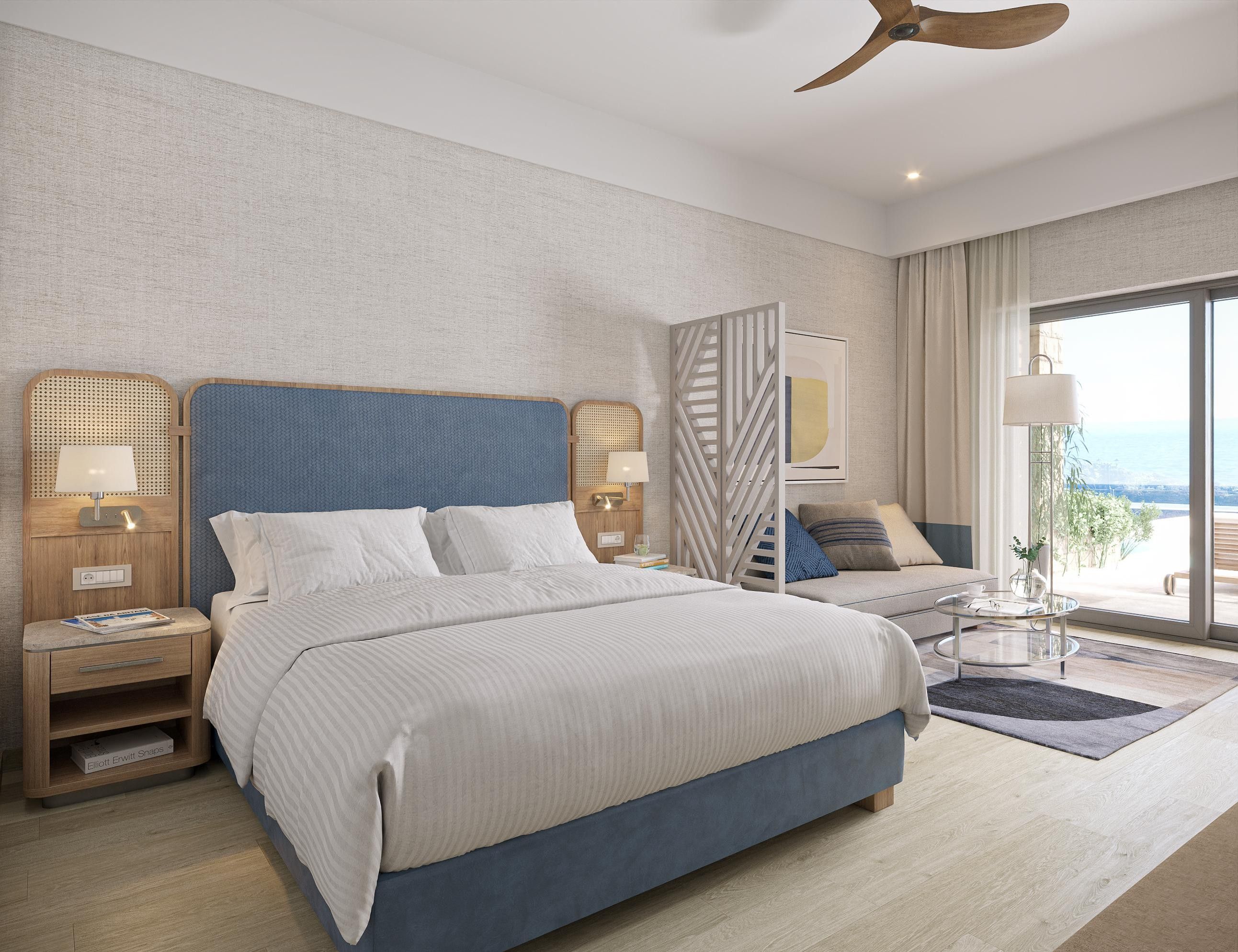 A modern hotel room with a large bed, a desk, and a view of the outdoors.