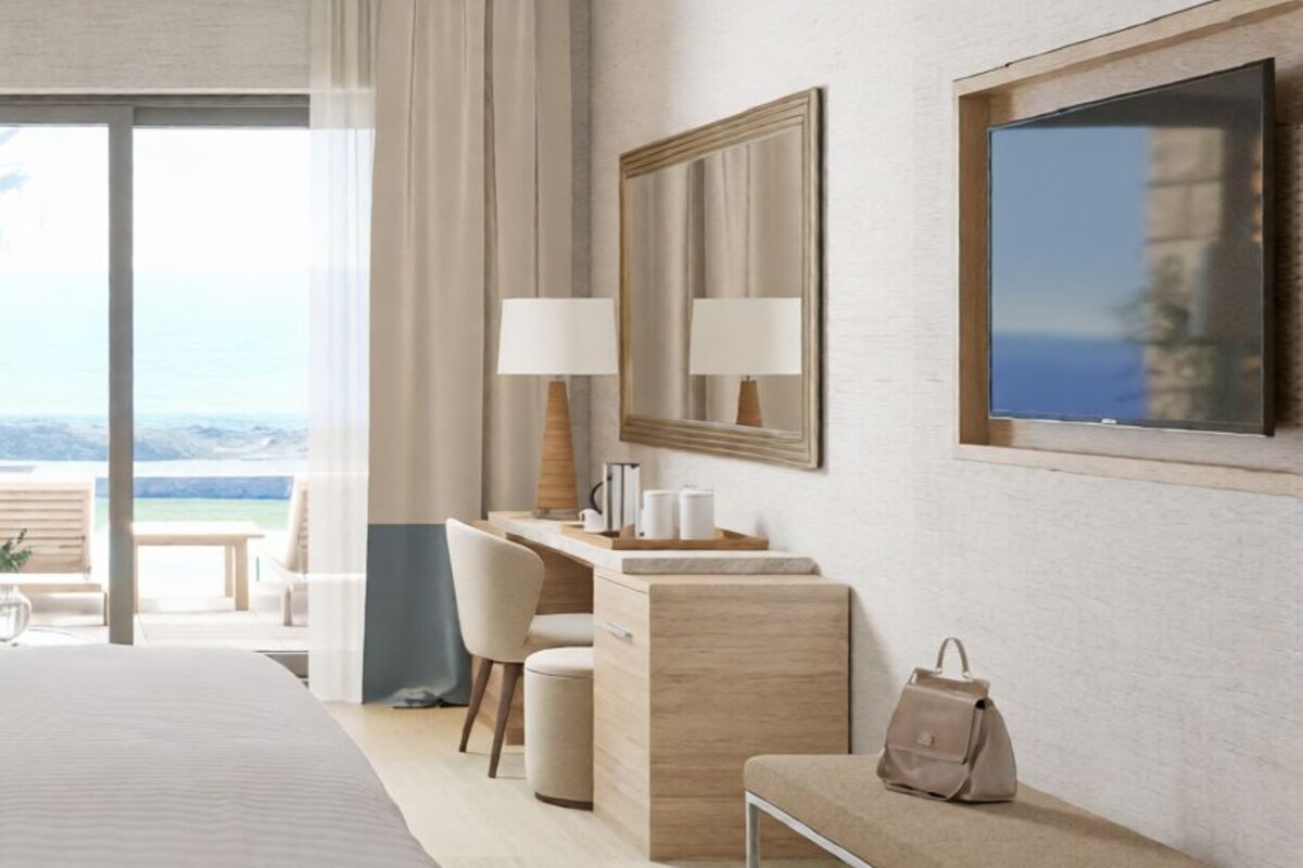 Ein modernes Hotelzimmer mit einem großen Bett, einem Schreibtisch, einem Stuhl, einer Bank, einem Fernseher und Blick ins Freie.