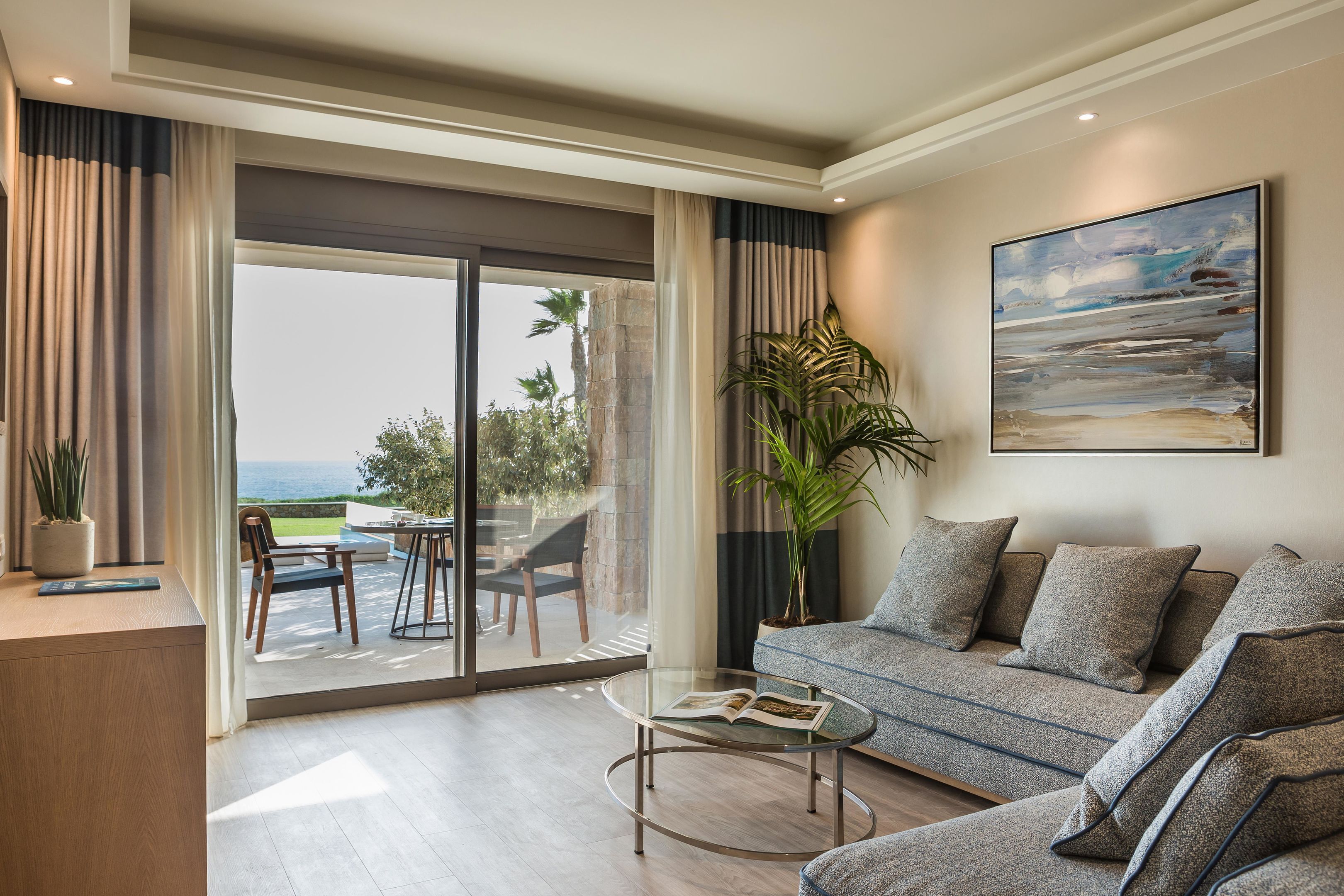 A modern living room with a sofa, coffee table, and a painting on the wall.