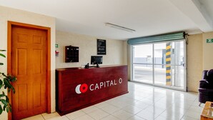 A reception desk with a sign reading "Capital O" and a wall-mounted information board. - Hotel San Pablo (San Pedro Cholula)