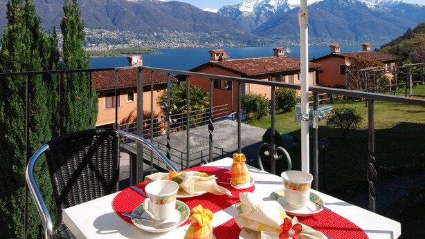 A table set for two with a view of mountains and a lake. - Casa Esmeralda GIOIA - 2-room apartment, approx. 45 m², with small balcony (Gambarogno)