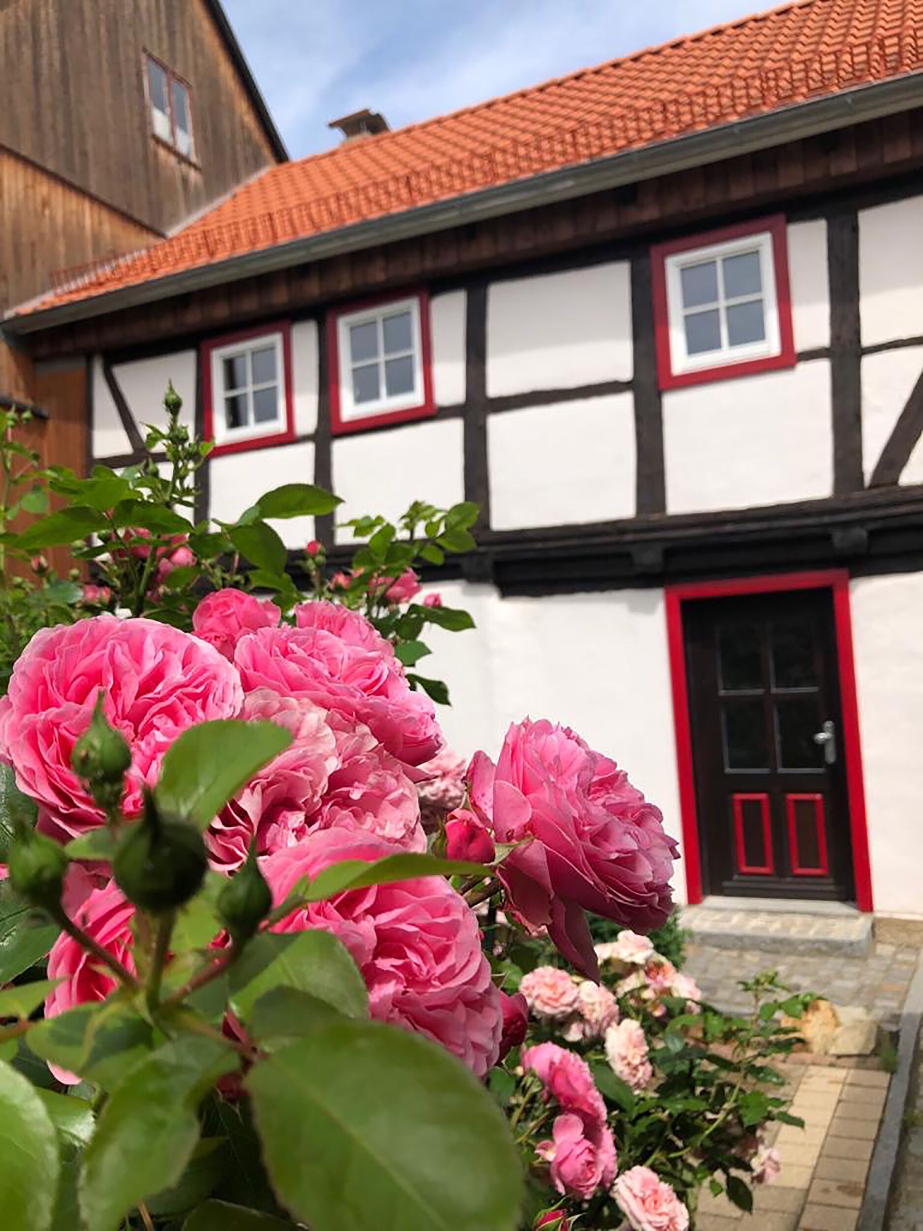 Una casa tradicional con entramado de madera, una puerta roja y paredes blancas.