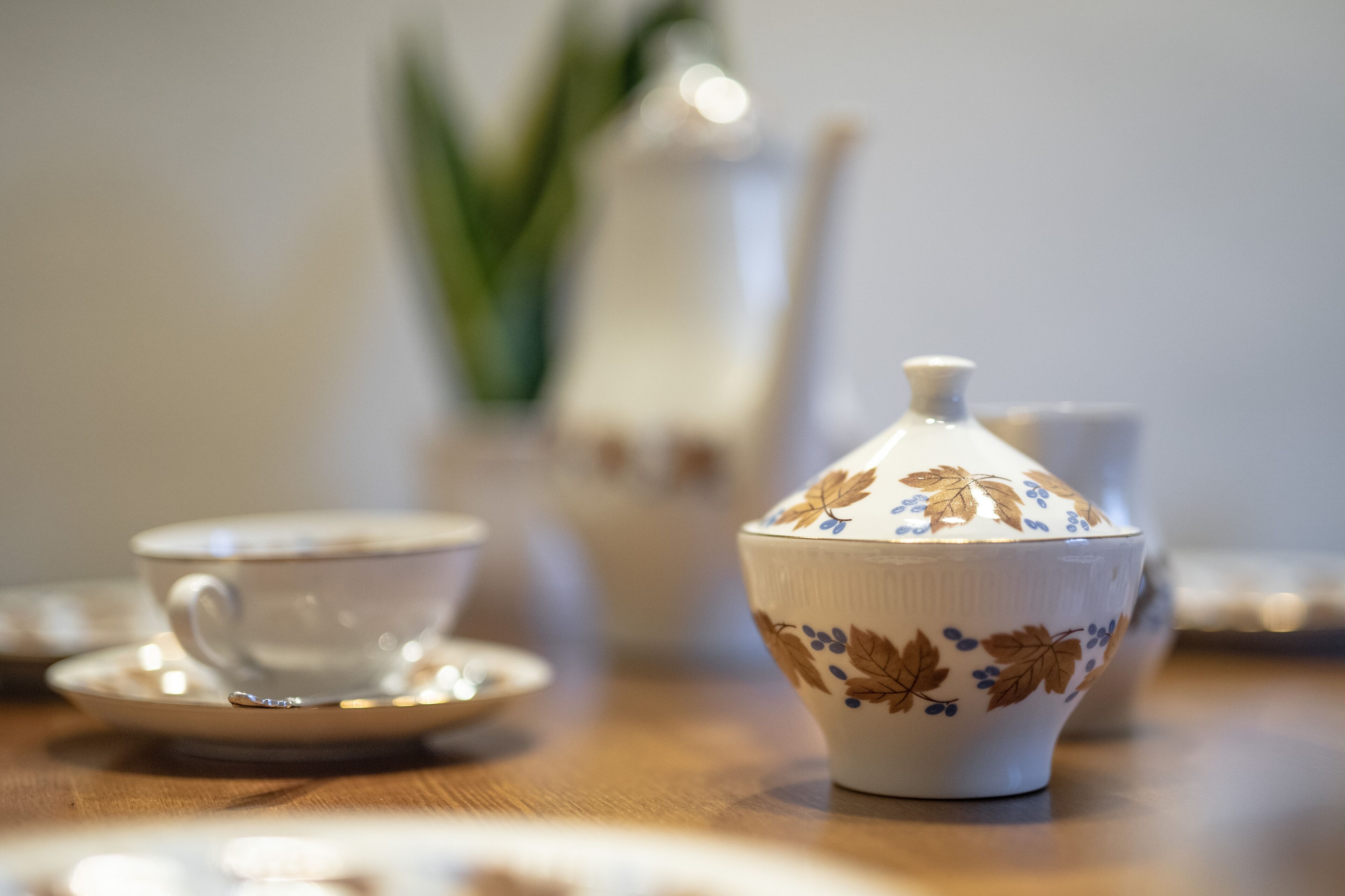 A table with a teapot, a cup, and a saucer.