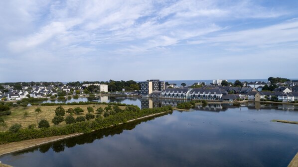 Vista de un lago con zona residencial, casas, un pequeño muelle y cielo despejado.