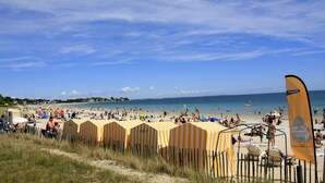 A beach with yellow striped beach huts and a clear blue sky. - Thalazur Carnac - Résidence (Carnac)