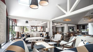 A modern living room with a sofa, armchairs, and a dining area. - Thalazur Carnac - Résidence (Carnac)