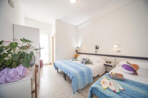 A hotel room with two beds, a desk, and a large plant. - Hotel Bologna (Misano Adriatico)