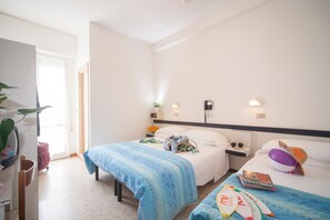A hotel room with two beds, a desk, and a chair. There are bedside tables with lamps and a small plant. - Hotel Bologna (Misano Adriatico)