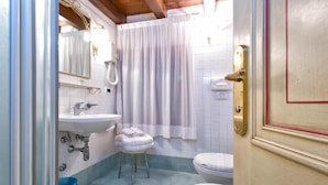 Un baño con lavamanos, inodoro y cortina de ducha.