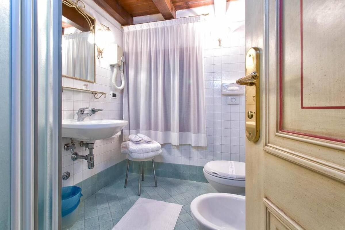 A bathroom with a sink, toilet, and a shower curtain.