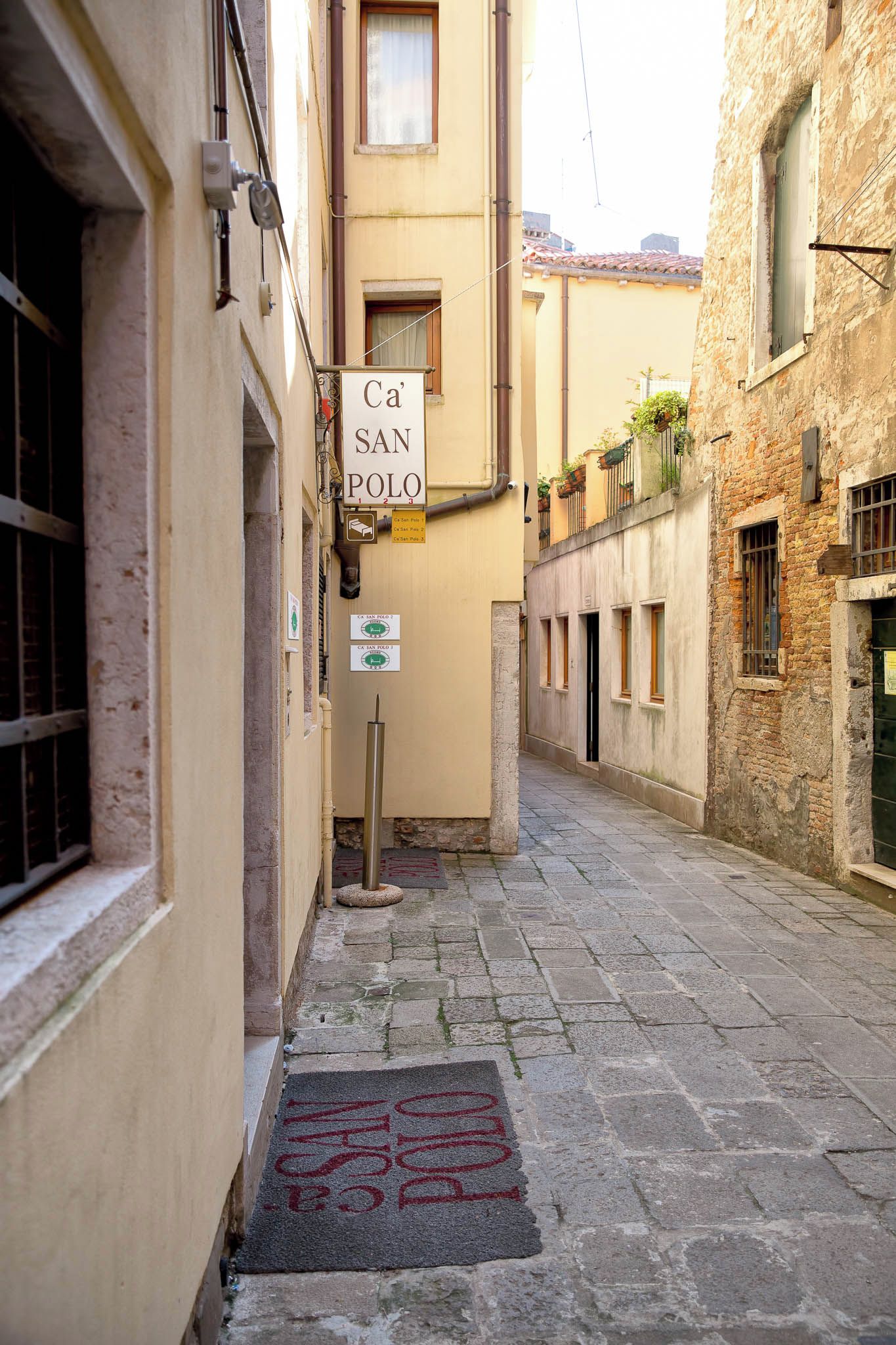A narrow street with a sign for 'Ca' San Polo' indicating a location.