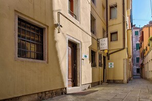 A narrow street with buildings on either side, a sign for 'Ca' San Polo,' and a visible door entrance. - Ca' San Polo - Ferretti Hotels Collection (Venice)