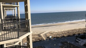 Ein Hotel direkt am Strand mit mehreren Balkonen, einem Sandstrand und Meerblick.