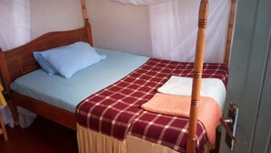 A four-poster bed with a canopy, a blue pillow, and a red and white checkered bedspread. - Mumbi Rose Guest House (Thika)