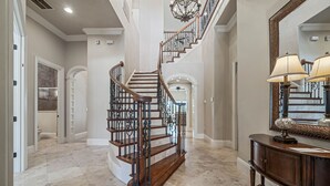 Eine prächtige Treppe mit aufwendiger Treppengeländern und einem Chandelier, die zu einer zweiten Etage führt.