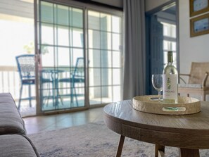 A room with a round wooden table, a bottle of Seaglass wine, and two glasses on a tray.