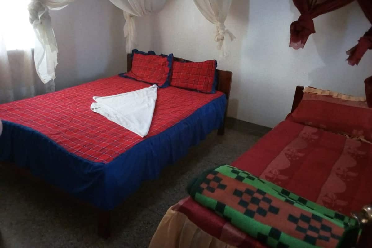 A room with a bed, a small table, and a chair.