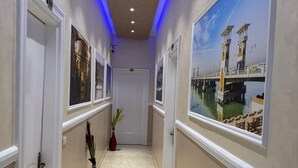 A hallway with a tiled floor, white doors, and a large window with a view of a bridge and water. - Golden Palace Hotel (Cairo)