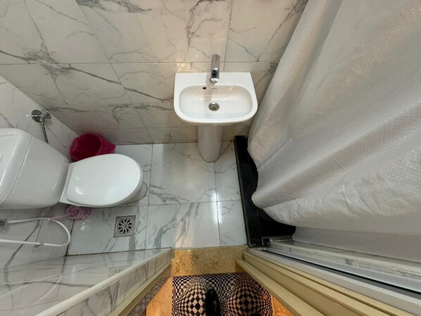 Un baño con lavamanos, inodoro y cortina de ducha.