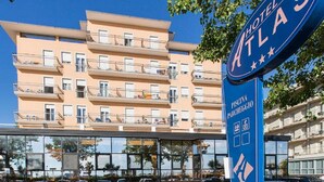 Un hotel llamado "Hotel Atlas" con un cartel que indica una zona de piscina.