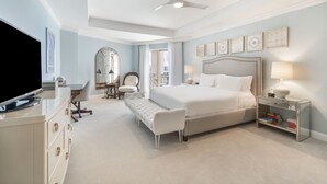 Un dormitorio espacioso con una cama grande, televisión, escritorio y una silla.