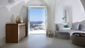 Un salon moderne avec vue sur la mer, un buffet en bois, un canapé et un vase.
