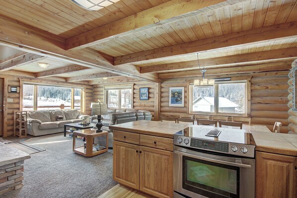 A log cabin interior with a living room, dining area, and kitchen.