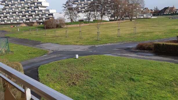 Una zona residencial con edificios de apartamentos modernos y un parque arbolado.