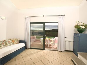 Relax in this cozy space with a sofa, cabinet, and table set, plus a balcony with outdoor seating.
