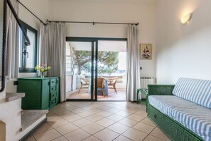 Relax in this open-plan room with a sofa and cabinet, and step out to a patio area with a table and chairs.
