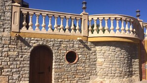 Un bâtiment en pierre avec une porte en bois et une fenêtre ronde.