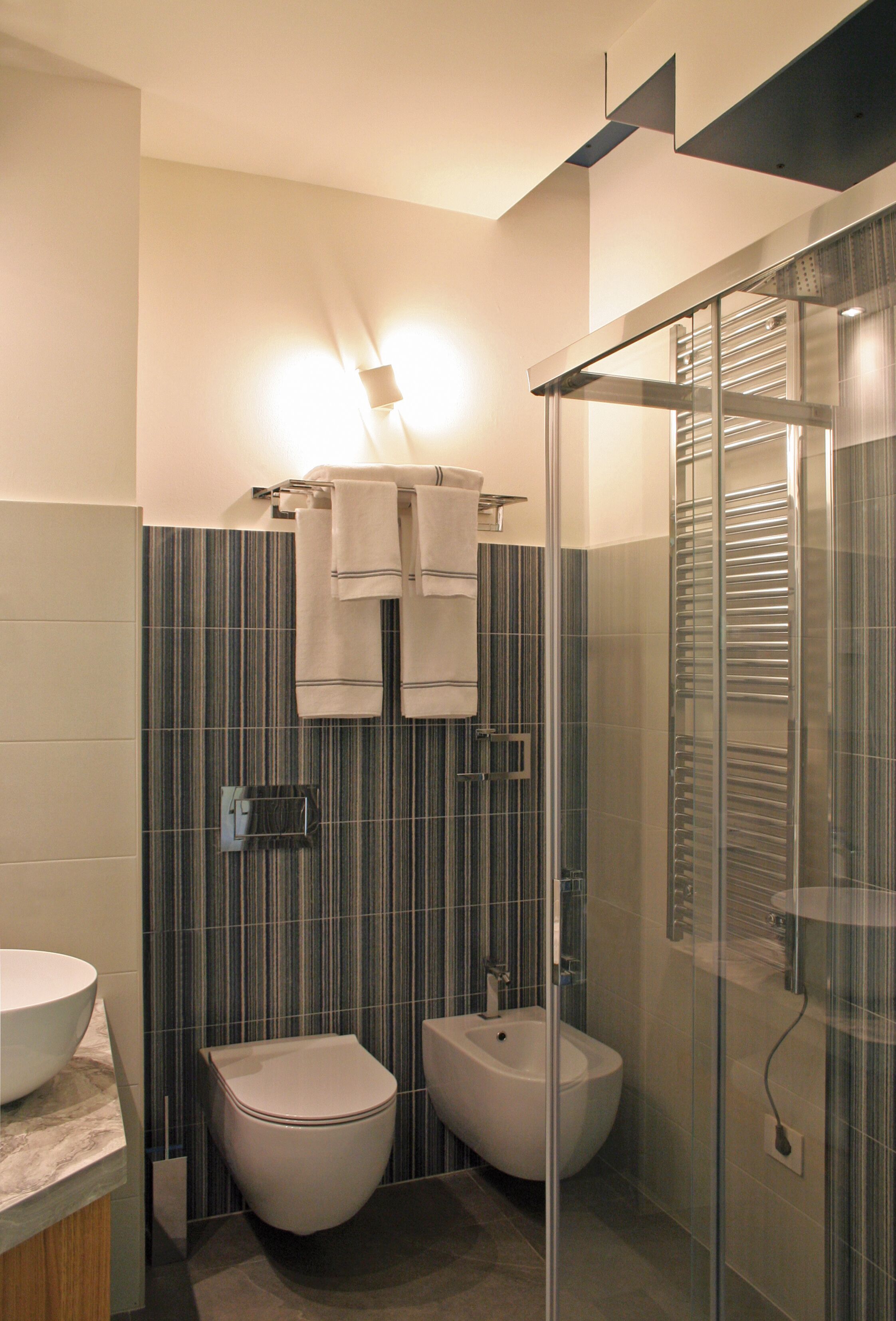 Un bagno moderno con servizi igienici, bidet e cabina doccia in vetro.
