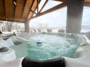 A hot tub with a view of a snowy landscape and a wooden ceiling structure. - Lake House Villa by HHSW (Logan)