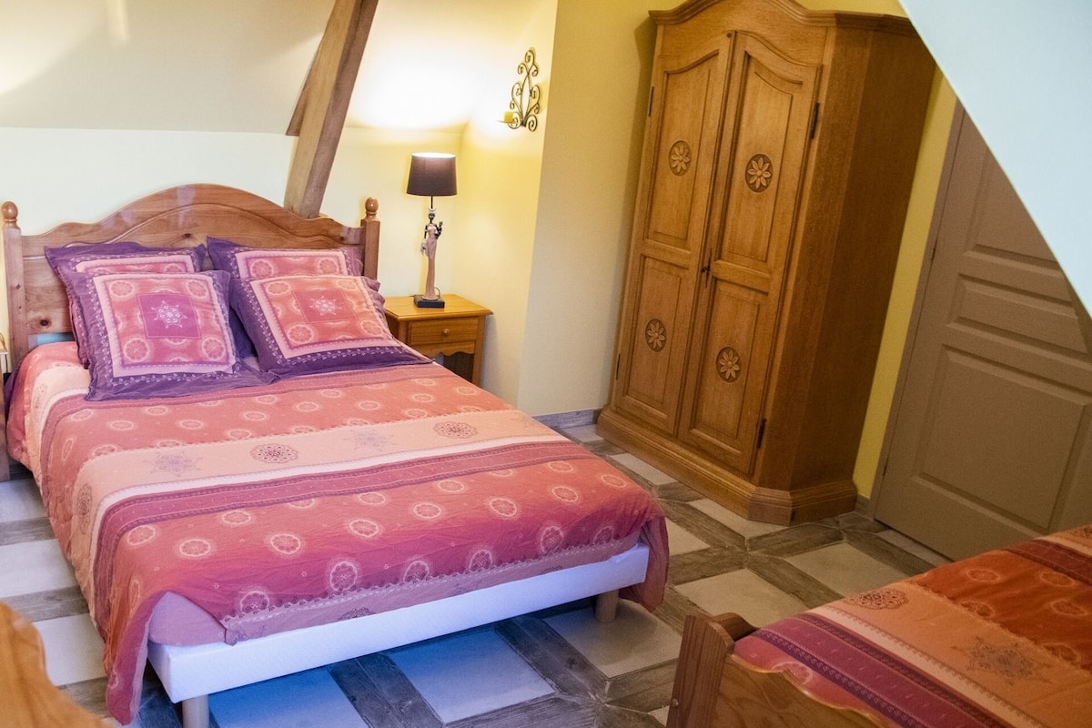 Une chambre à coucher avec un lit en bois, une table de chevet avec une lampe et une armoire.