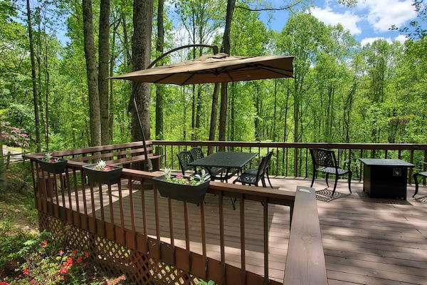 Private creekside deck with outdoor dining, fire table, and peaceful mountain surroundings