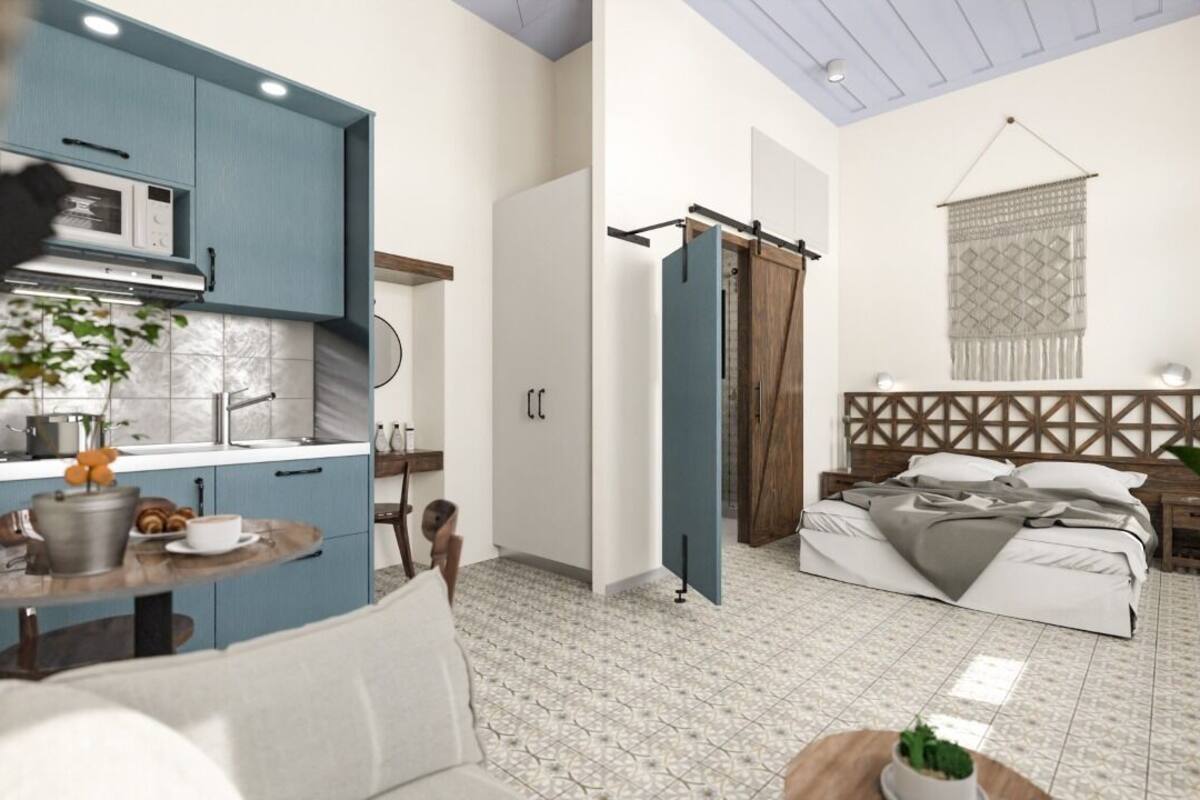 A compact living space with a kitchenette, a bed, and a dining area.