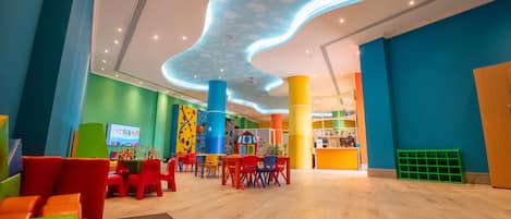 A brightly lit indoor space with colorful seating arrangements and a unique ceiling design.